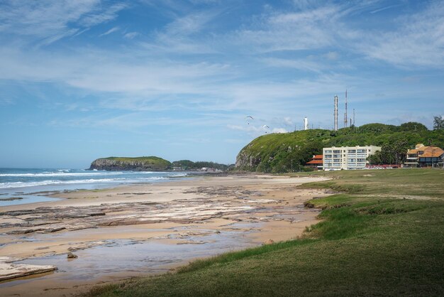 Photo la plage de prainha avec la colline du phare morro do farol et la colline de furnas morro das furnas torres rio grande do sul au brésil