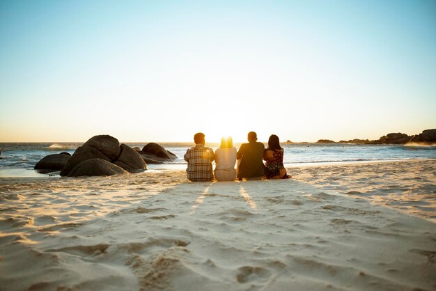 Une plage avec quatre personnes assises ensemble