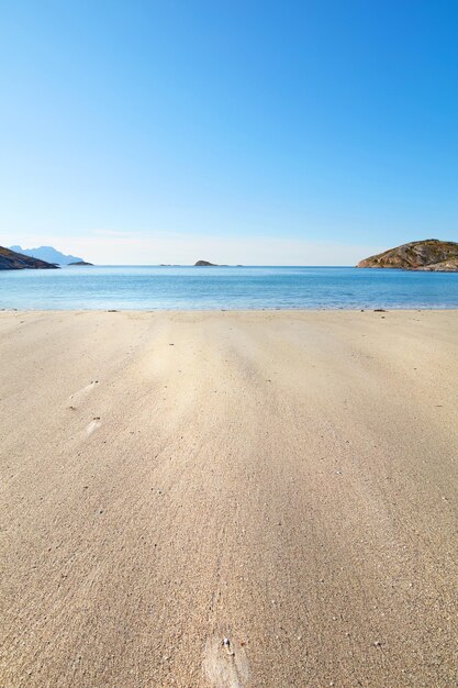 Une plage relaxante un jour d'été idéale pour les vacances Océan bleu calme sable beige avec des îles en arrière-plan Une côte isolée dans la ville de Bodoe au nord du cercle polaire