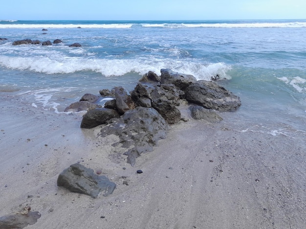 Une plage avec des rochers et l'océan en arrière-plan