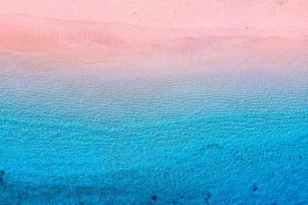 Plage rose et océan en arrière-plan depuis la vue de dessus Fond bleu de l'eau du drone Paysage marin d'été depuis l'air Image de voyage et de vacances