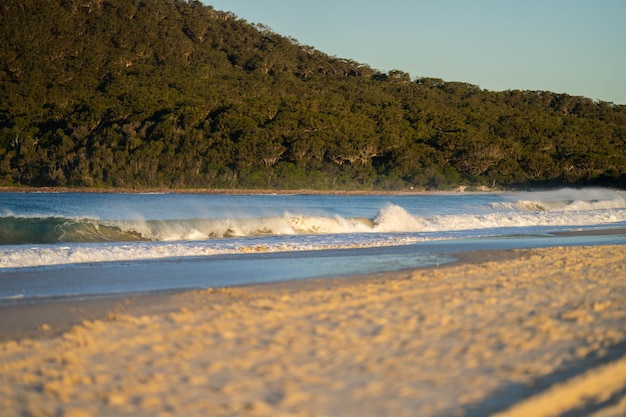 plage de sable au crépuscule dans le Queensland en Australie avec des vagues qui se brisent en été