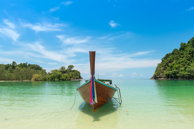 Plage de sable blanc et bateau à longue queue à l’île de Kham-Tok (koh-kam-tok