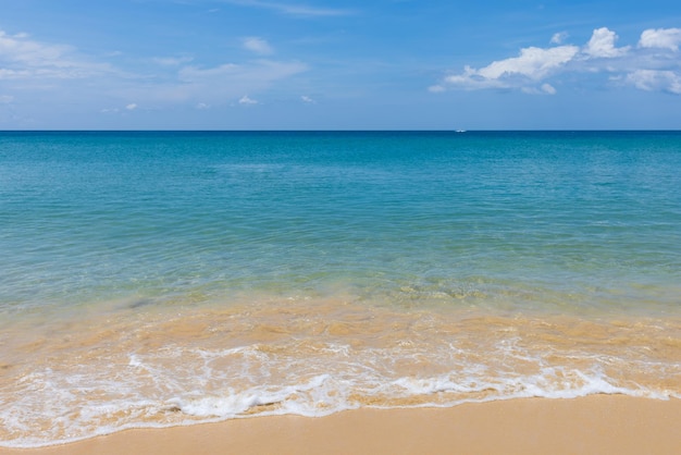 Plage de sable d'eau claire et ciel bleu