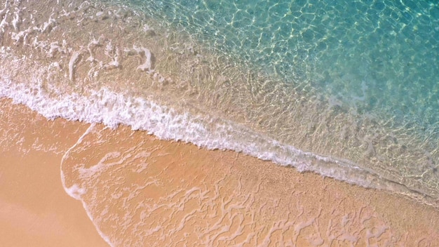 Plage de sable lavant par des vagues turquoises claires vue aérienne d'en haut le paradis d'été