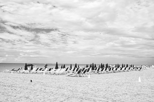 Plage de sable avec transats et parasols roses pliés