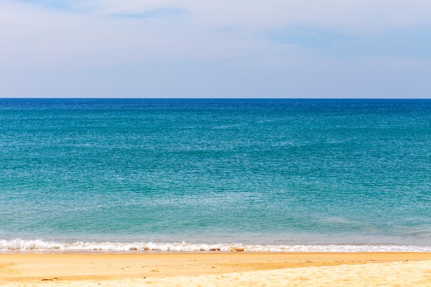 Plage de sable tropicale avec l'océan bleu et l'image de fond de ciel bleu pour le fond de la nature ou l'été.