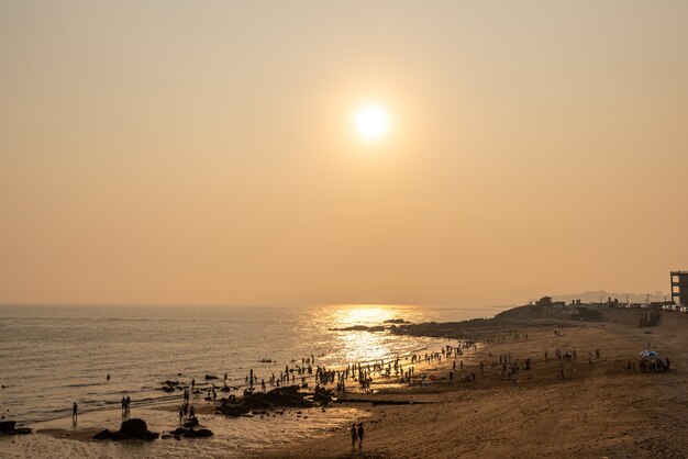 La plage sous le soleil couchant est dorée.