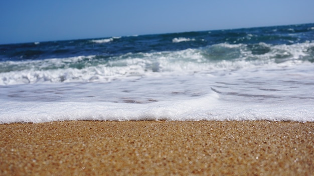 Plage tropicale. Fond de vague de l'océan. Sable et mer bleue. Nature de l'eau de mer, détente sur la plage. Vacances d'été à la mer