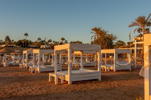 Plage tropicale avec parasols au coucher du soleil Tourisme et voyages