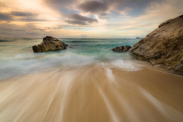 Une plage avec des vagues et un ciel nuageux