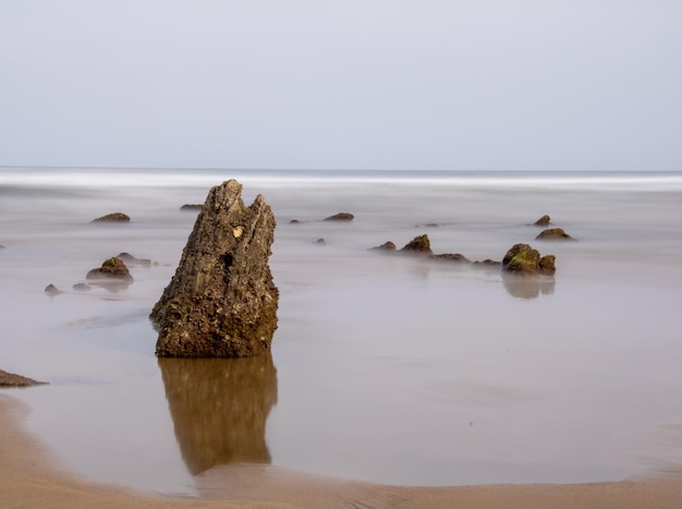 plage avec vagues et rochers par beau temps