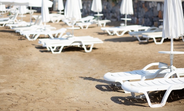 Plage vide avec chaises longues et parasols fermés pendant l'épidémie du virus Covid 19. Notion de quarantaine. La crise de l'industrie touristique. Mise au point sélective.