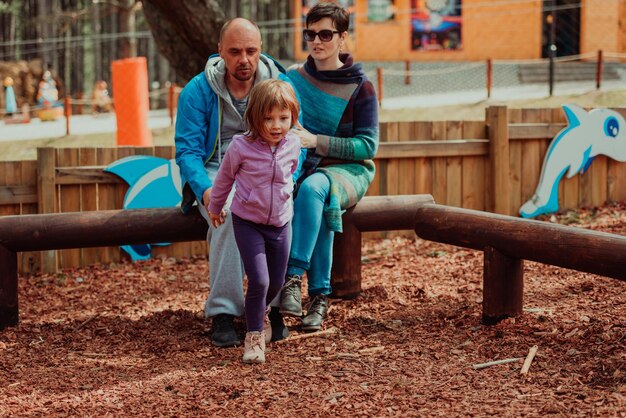 Plaisir en famille dans le parc. Héhé, passer du temps dans le parc et jouer avec leur fille.