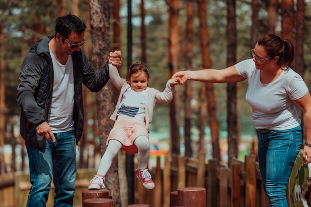 Plaisir en famille dans le parc. Héhé, passer du temps dans le parc et jouer avec leur fille.