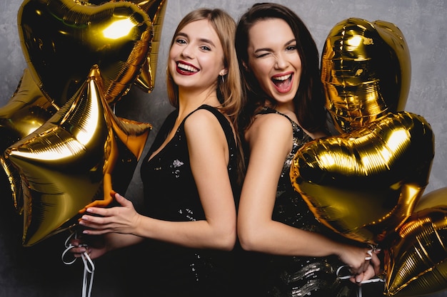 Plaisir de fête. Belles filles célébrant le nouvel an. Portrait de magnifiques jeunes femmes souriantes appréciant la célébration de la fête, s'amusant ensemble. Image de haute qualité.