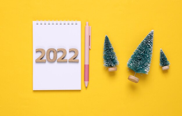 Plan 2022 Cahier avec stylo arbres de noël sur fond jaune