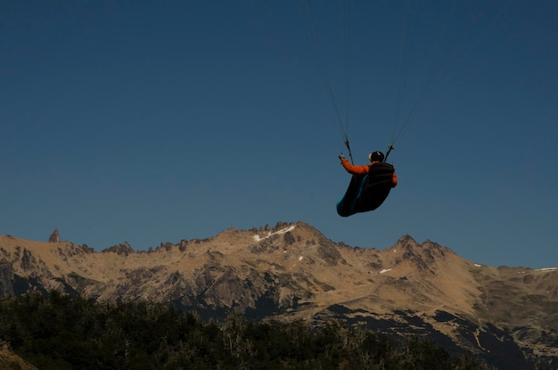 Plan arrière d'un parapente volant vers la montagne avec espace de copie