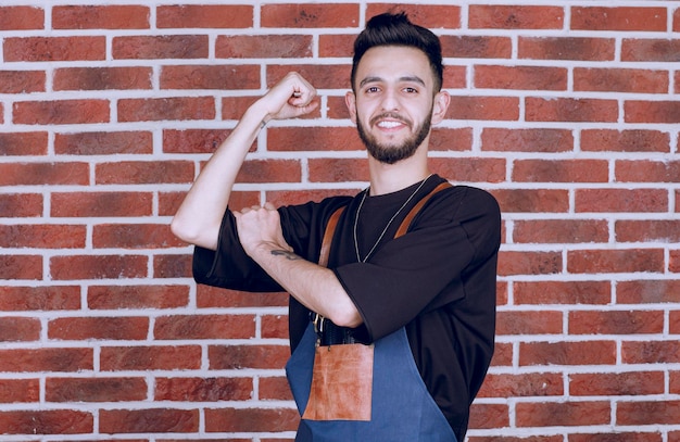 Plan d'un coiffeur brune montrant ses muscles. Photo de haute qualité