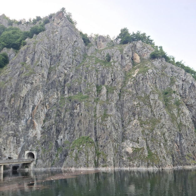 Un plan d'eau avec un pont et une montagne