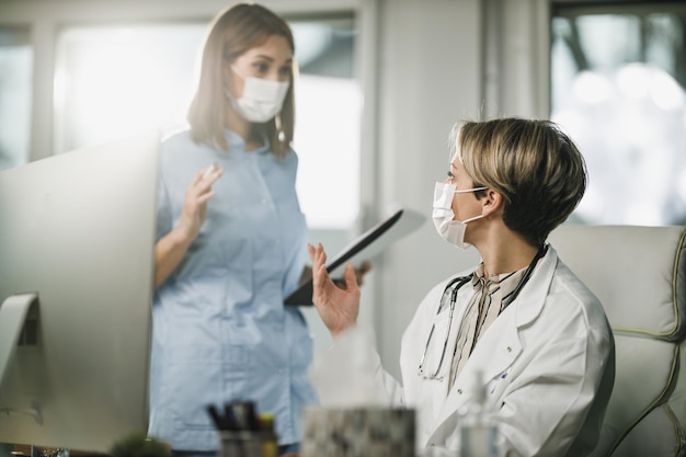 Plan d'une femme médecin et d'une jeune infirmière travaillant ensemble dans une salle de consultation à l'hôpital.