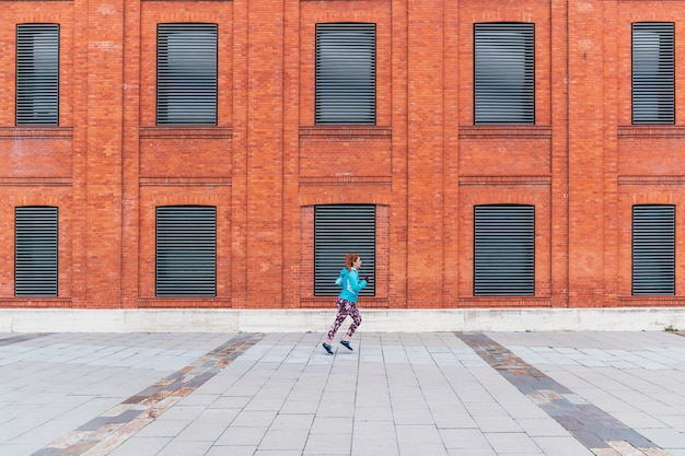 Un plan général d'une femme rousse sportive en cours d'exécution en plein air