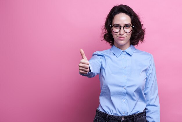 Plan horizontal d'une femme aux cheveux noirs joyeuse se sent ravie, habillée avec désinvolture,