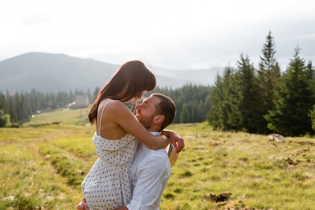 Plan d'un jeune homme portant sa belle petite amie dans les bras. Couple profitant de la nature un jour d'été.