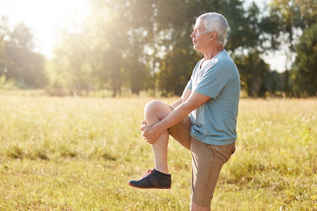 Plan latéral d'un homme âgé en bonne santé étire les jambes