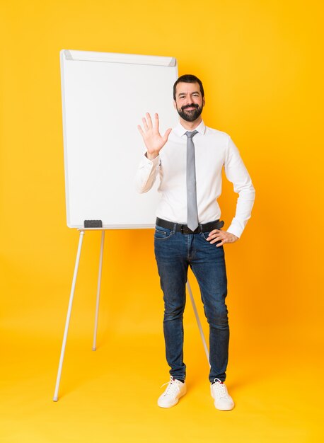 Plan long d'un homme d'affaires donnant une présentation sur tableau blanc