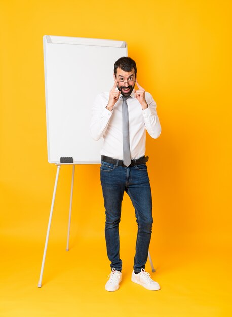 Plan long d'un homme d'affaires donnant une présentation sur tableau blanc