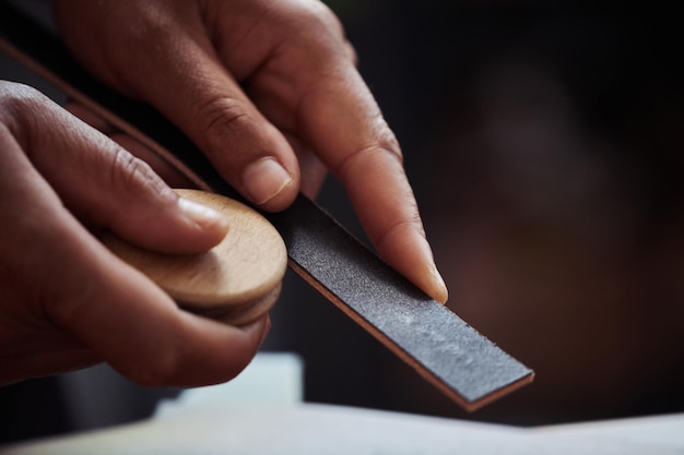 Plan macro sur un artisan méconnaissable en cuir fait main de ponçage dans un atelier de maroquinerie copie savs