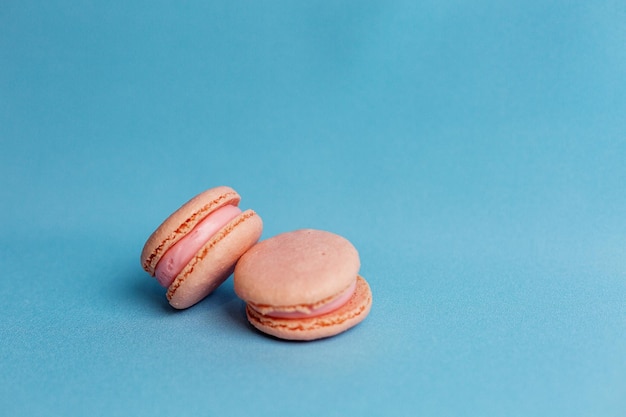 Le plan médian d'un gâteau coloré avec des biscuits aux amandes aux couleurs pastel sur fond bleu