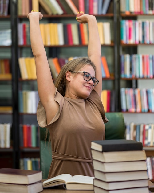 Plan moyen femme qui s'étend à la bibliothèque