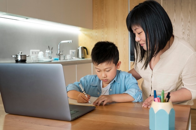 Photo plan moyen mère et enfant à faire leurs devoirs