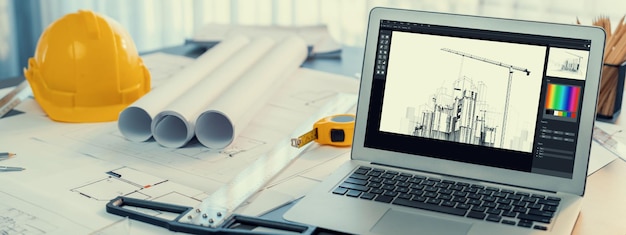 Photo plan numérique par logiciel de conception d'architecture sur l'écran de l'ordinateur portable avec des documents et une disposition de plan sur la table de bureau intégration transparente de la technologie et de la méthode de rédaction traditionnelle insight