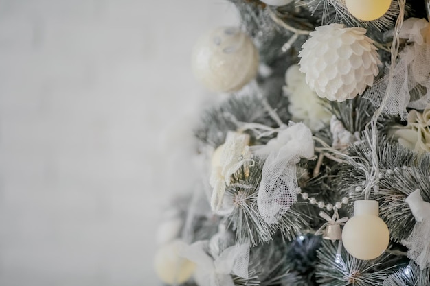 Photo plan rapproché d'un arbre de noël avec des jouets blancs sous forme de decorationsplace pour insérer du texte