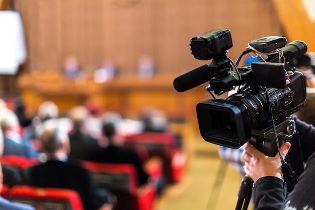 Plan rapproché d'une caméra vidéo filmant un séminaire, une réunion, une conférence