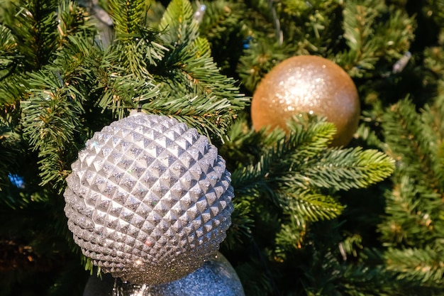 Plan rapproché des décorations et de la guirlande d'or et de nouvel an sur l'arbre de Noël dehors