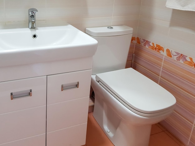 Plan rapproché du lavabo et de la cuvette des toilettes dans une belle salle de bains moderne