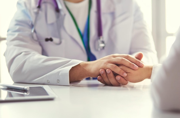 Plan rapproché du stéthoscope et du papier sur le fond des mains de docteur et de patient