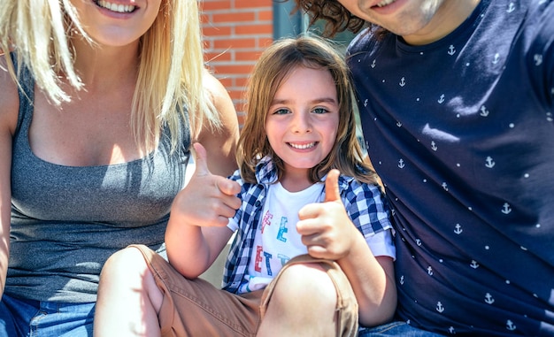 Plan rapproché d'enfant avec des parents s'asseyant devant leur nouvelle maison