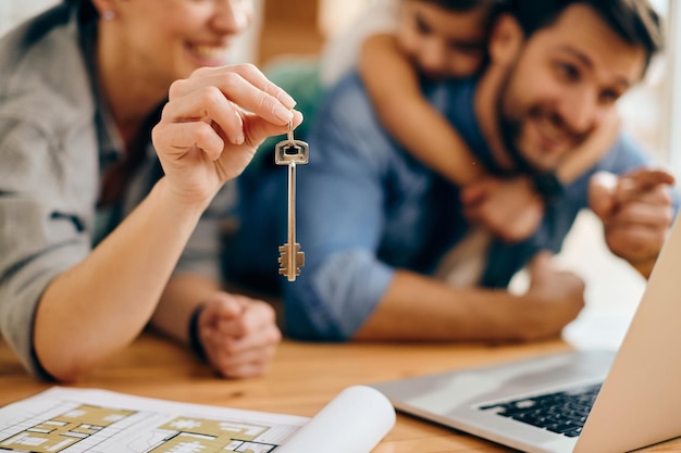 Plan rapproché de famille avec une clé de leur nouvelle maison