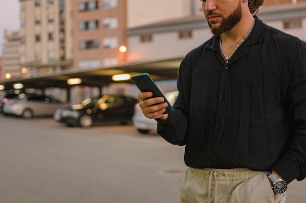 Plan rapproché d'un homme d'affaires avec un téléphone portable dans un parking