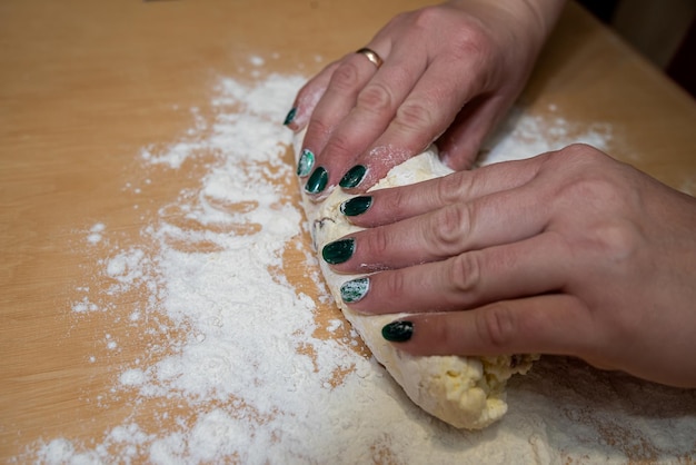 Plan rapproché des mains femelles déployant la pâte douce pour la cuisson