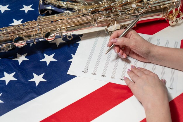 Photo plan rapproché des mains femelles écrivant les notes musicales dans la perspective du drapeau américain