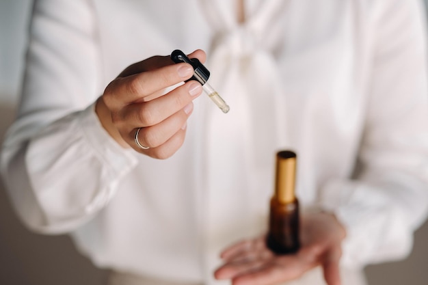 Plan rapproché des mains femelles tenant une bouteille d'aromathérapie d'huile essentielle