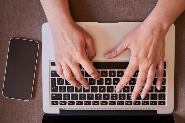 Plan rapproché des mains de la femme d'affaires tapant avec un ordinateur portable