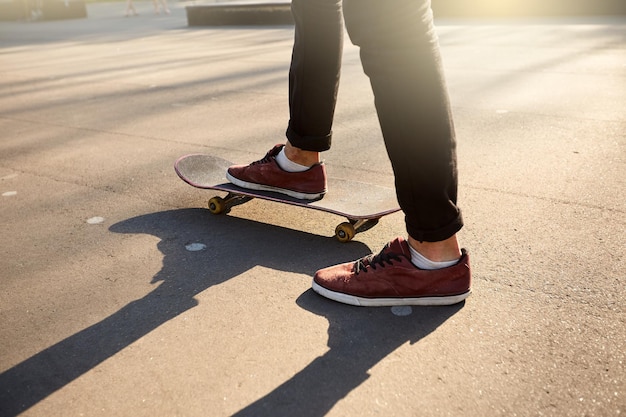 Photo plan rapproché des pieds de planchistes tout en patinant dans le skate park man riding on skateboard vue isolée low angle shot