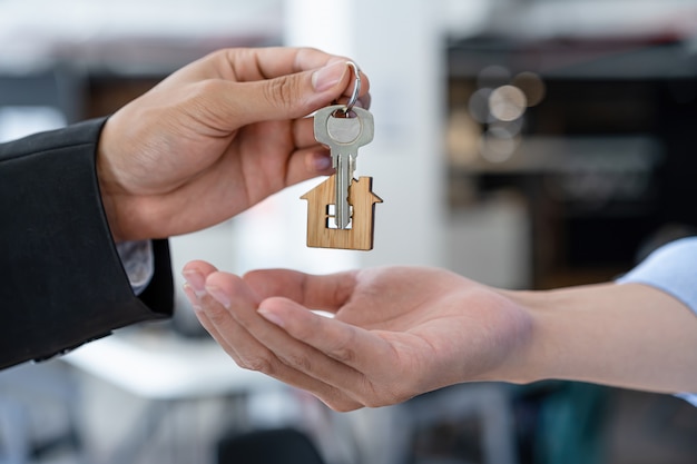 Plan recadré d'un agent immobilier ou d'un banquier donnant une clé de la maison à l'acheteur.